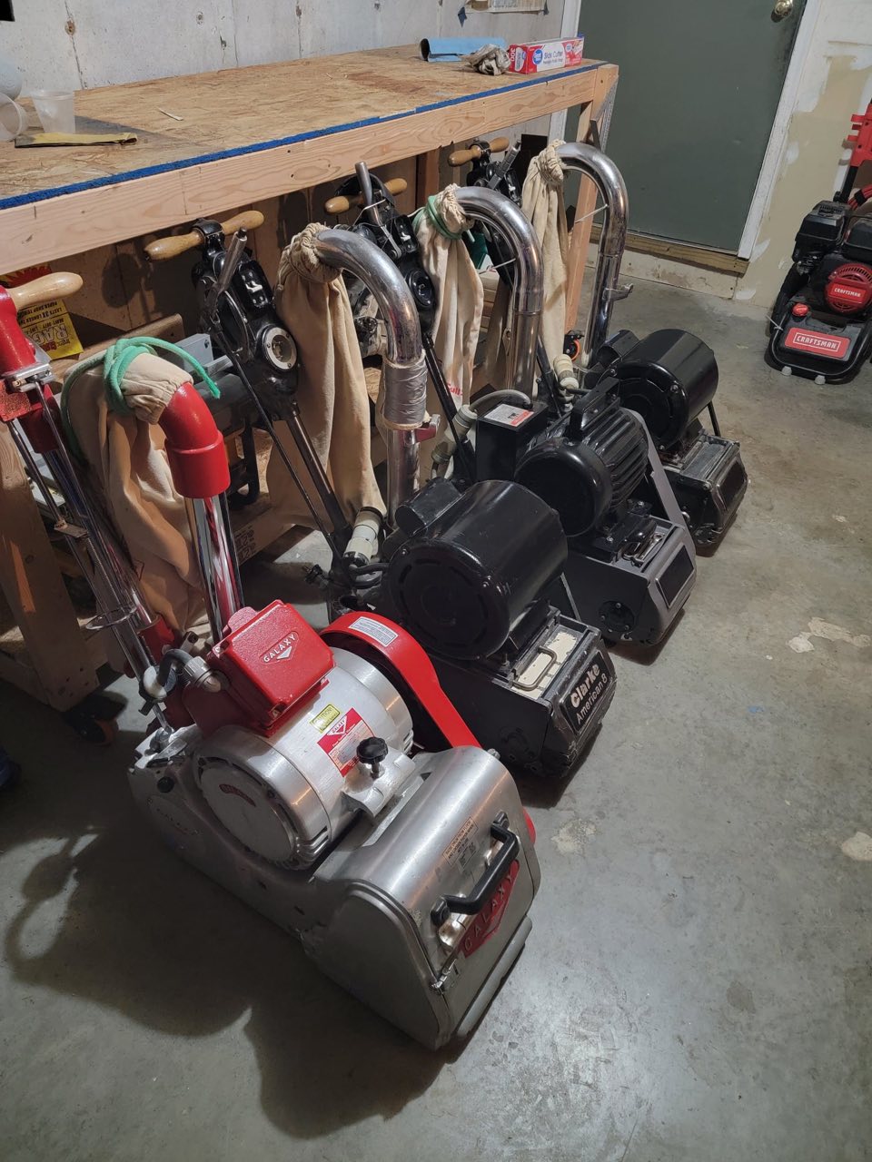The Russotto fleet of professional floor sanders — vintage Galaxy drum sanders and Clarke American edgers lined up in the shop