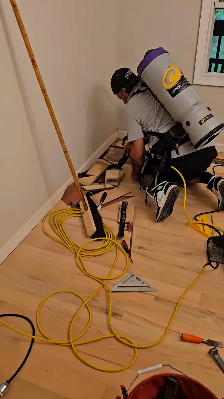 A Russotto installer fitting new hardwood boards along the wall