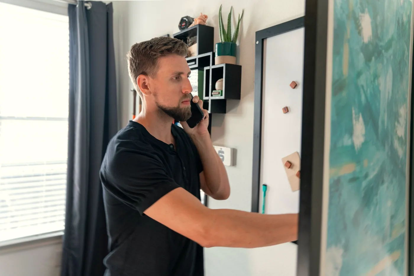 A homeowner on the phone at home, calling to book a free in-home floor estimate